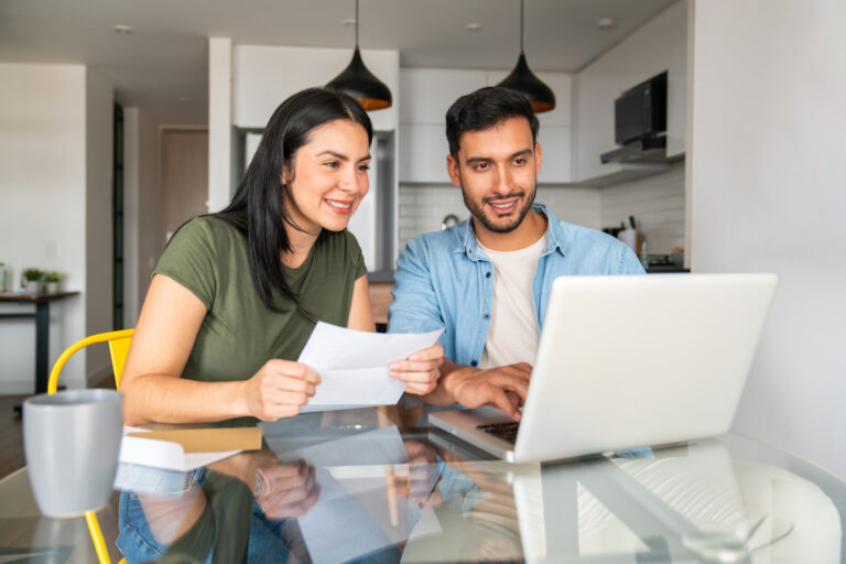 Couple researching the 2026 Arizona flat tax and California relocation math on a laptop.
