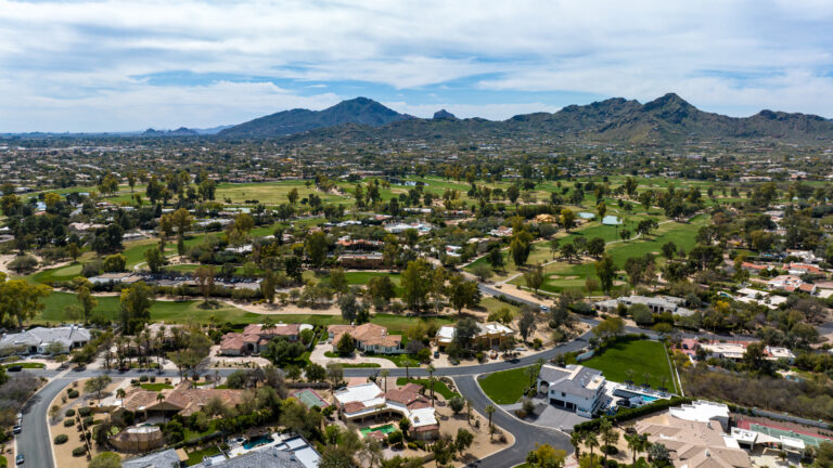 Aerial photograph of a North Scottsdale neighborhood featuring luxury homes with private pools adjacent to the McDowell Sonoran Preserve hiking trails.